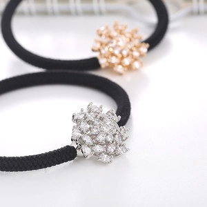 Macro detail of rhinestone snowflake hair ties with silver and gold metal bases