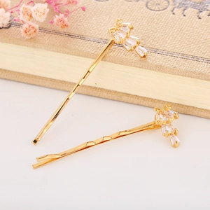 Close-up of golden wave hair clips with sparkling zircon stones on a decorative book