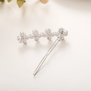 Détail macro d'une barrette trèfle argentée avec des pierres de zircon brillantes