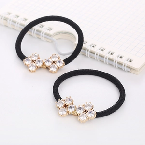 Close-up of two black elastic hair ties featuring glittering zircon butterfly accents