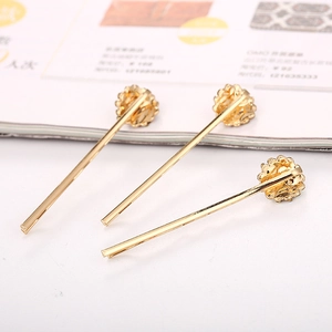 Détail de trois barrettes dorées à fleurs en cristal sur fond de magazine de mode