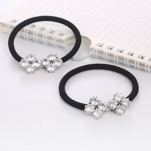 Close-up of black elastic hair ties featuring luxury cubic zirconia bow decorations
