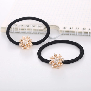 Detail of high-elastic black hair ties featuring gold snowflake pendants with shiny zircons