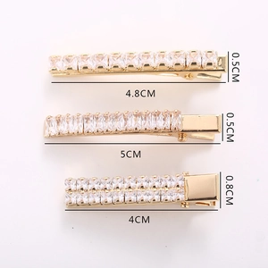 Golden alloy hair clips set with sparkling cubic zirconia crystals in three sizes