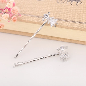 Vista macro di due fermagli per capelli da ballerina in argento con cristalli di zircone su un libro