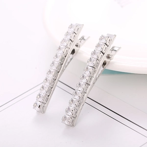 Detail view of two silver duckbill hair clips with sparkling square cubic zirconia stones