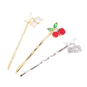Lot de trois barrettes cerise avec strass rouges et blancs sur base dorée et argentée