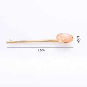 Barrette dorée avec résine orange pailletée ovale et dimensions précises de 5,6 cm