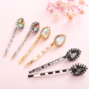 Detail view of water drop crystal bobby pin set in gold silver and gun black finishes
