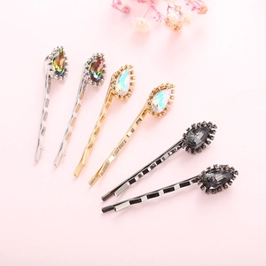 Detailed view of teardrop crystal hairpins with vibrant rhinestones on metal clips