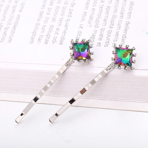 Détail de barrettes argentées avec cristaux arc-en-ciel carrés et strass brillants
