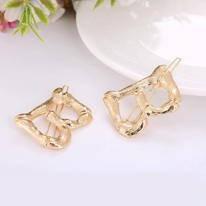 Detailed macro view of gold-plated letter B hairpins with bamboo texture finish