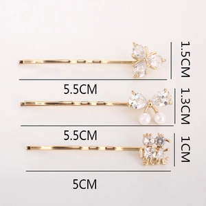 Ensemble de trois barrettes dorées avec fleurs en zircon et perles sur fond rose