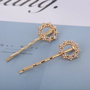 Elegant gold-tone hair clip set with white faux pearls and crystals on blue background