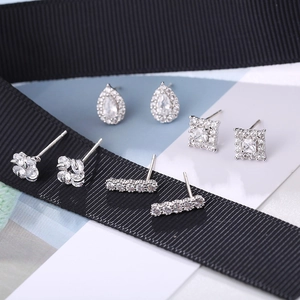 Macro detail of four S925 sterling silver stud earrings with zirconia in various shapes