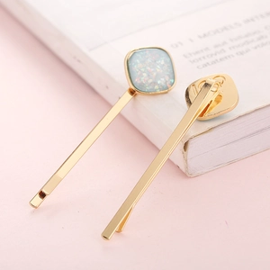 Detail of gold-plated metal hair clips with light blue glitter square inlay ornaments