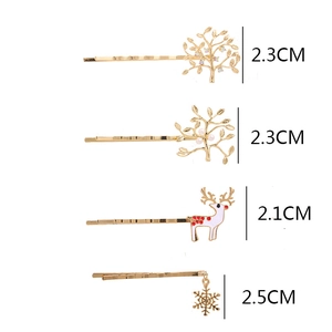 Detailed view of four golden hair pins with deer, snowflake, and tree rhinestone charms