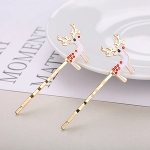 Golden reindeer hair pins with white enamel finish and red accents in minimalist style