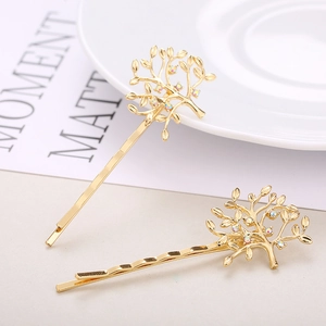 Detail of golden tree hairpins with sparkling rhinestones on decorative plate