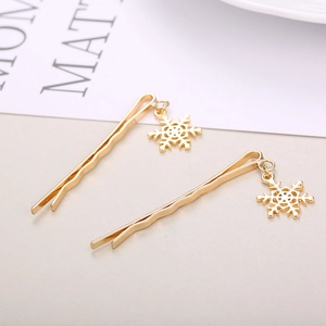 Elegant pair of gold wavy hair clips featuring delicate snowflake pendants for women