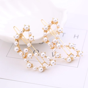Detail von 2er-Set goldene Haarklammern mit eleganten weißen Perlen auf einer Schale