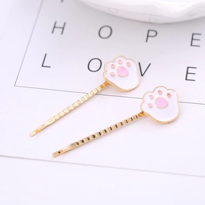 Cute golden cat paw hair clips with white and pink enamel detail for sweet summer styling