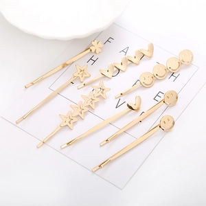 Ensemble de pinces à cheveux dorées minimalistes avec étoiles et cœurs sur carte blanche