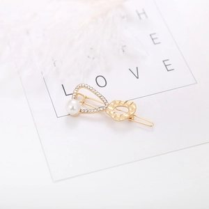 Elegant gold hair clip set with white pearl and sparkling rhinestones on white background
