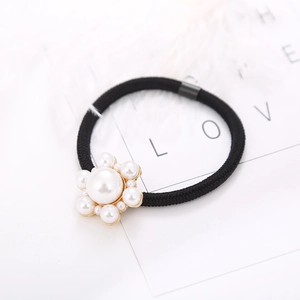 Close-up of elegant pearl flower hair tie with black high-elastic band and golden base