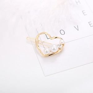 Elegant gold hollow heart hair clip featuring three white pearls and a small rhinestone