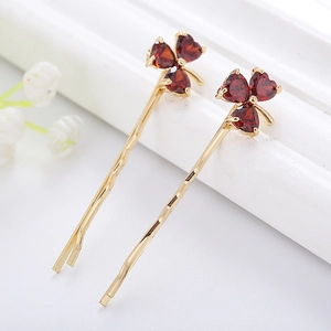Elegantes Set aus goldenen Haarklammern mit roten Herzsteinen im Kleeblatt-Design