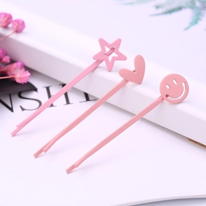Nahaufnahme von rosa matten Haarspangen mit Stern-, Herz- und Smiley-Hohlmustern