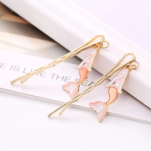Barrettes sirène dorées avec breloques dégradées rose sur fond minimaliste chic