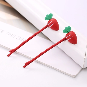 Gros plan sur des barrettes mignonnes en forme de carotte avec finition rouge et feuilles vertes