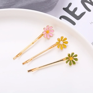 Three-piece set of daisy hair clips in pink, yellow, and green with golden metal base