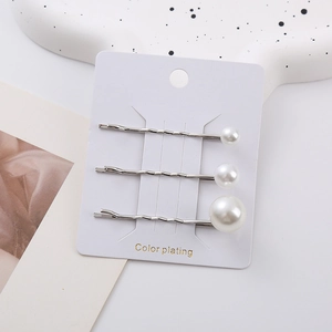 Three-piece set of minimalist silver wavy hairpins with white faux pearls on white card