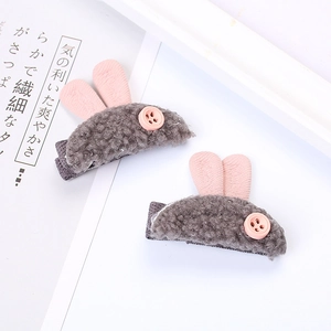 Détail de pinces à cheveux lapin en polaire grise avec yeux boutons roses et oreilles