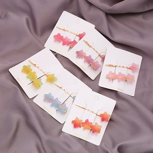 Lot de 5 barrettes étoiles colorées dégradées avec texture pailletée sur tissu gris