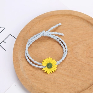 Détail de l'élastique à cheveux bleu ondulé avec un ornement de tournesol jaune