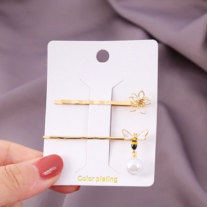 Haarklammer-Set in Gold mit einer hohlen Metallblume und Biene mit weißem Perlenanhänger