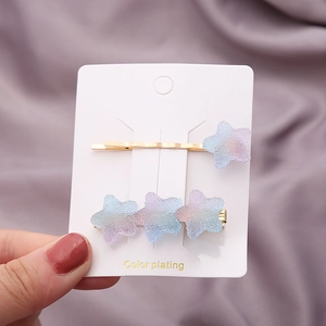 Détail de barrettes étoiles colorées avec dégradé arc-en-ciel sur supports en métal doré