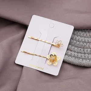 Set of two gold flower hair clips with minimalist metal petals and crystal accents