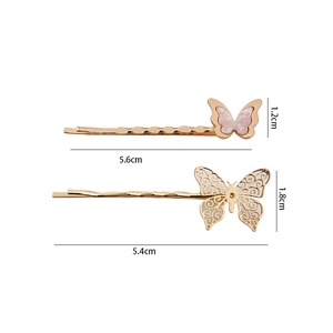 Detail showing dimensions of two gold butterfly hair clips with marble pattern and filigree