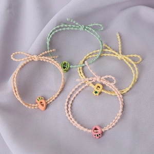 Détail de quatre élastiques à cheveux colorés avec breloques en résine de fruits