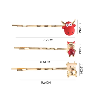 Vue détaillée de trois barrettes de boeuf doré avec résine rouge et cristaux brillants