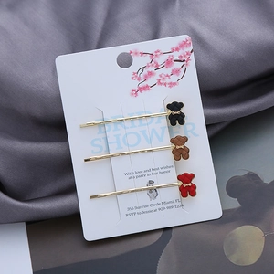 Détail de trois barrettes à cheveux ours avec texture matelassée sur carte de support rose Sakura