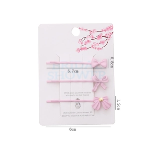 Lot de trois barrettes à nœuds roses sur carte de présentation avec dimensions indiquées