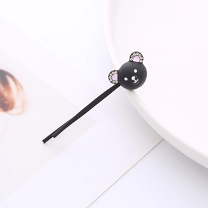Barrette à cheveux ours noir mignon avec oreilles en strass sur un plateau minimaliste