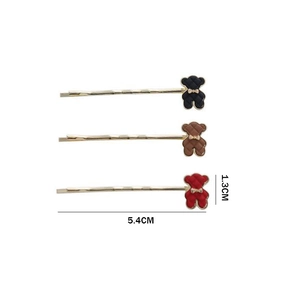 Détail de trois barrettes ours en noir, marron et rouge avec une base en métal doré brillant