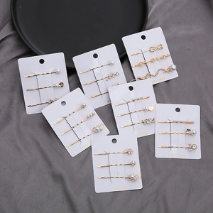 Elegantes Haarspangen Set in Gold mit Perlen und Strass auf seidigem Hintergrund